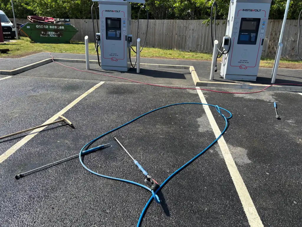 A car park mid-clean, hoses still down
