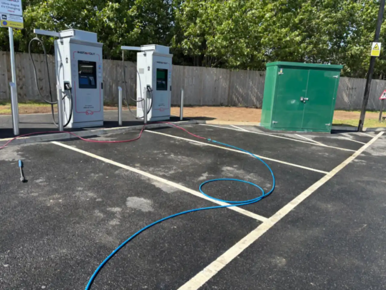 A car park part way through cleaning, with EV chargers behind