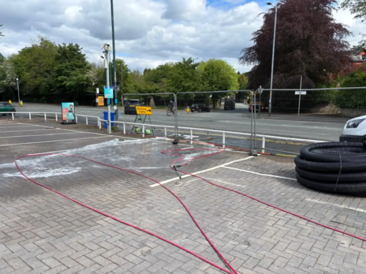 Block paving being pressure washed, foam still on the surface